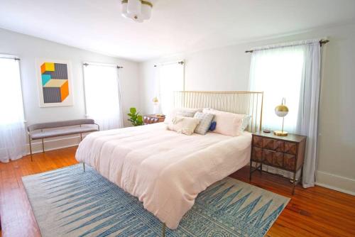 a bedroom with a large white bed and a rug at Carriage House on Chatham Sq in Savannah