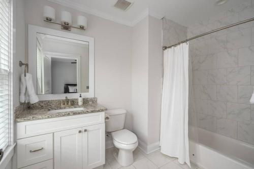 a bathroom with a toilet and a sink and a mirror at Rose carriage House Savannah in Savannah