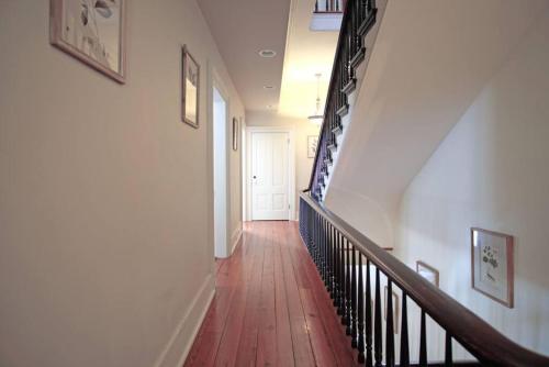 a hallway with a staircase with a wooden floor at Hamilton House - 5BR Historic Home with Courtyard and Garage in Savannah