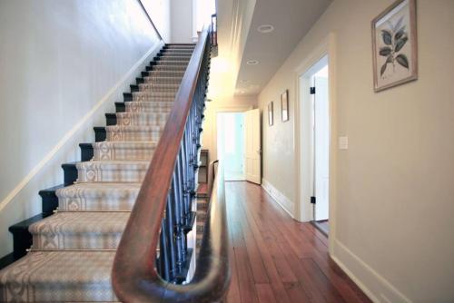 a staircase in a house with a wooden stair case at Hamilton House - 5BR Historic Home with Courtyard and Garage in Savannah