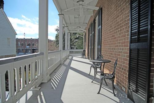 a balcony with a table and chairs on a brick building at Hamilton House - 5BR Historic Home with Courtyard and Garage in Savannah