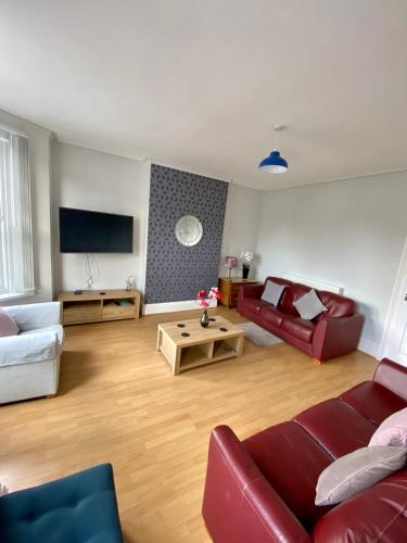a living room with two couches and a tv at Eden Stay 5 Bedroom House in Morecambe