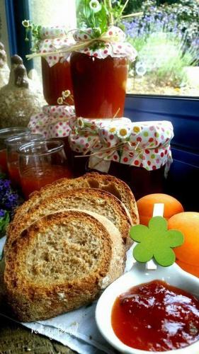a sandwich on a table with a plate of jam and fruit at Chambres d'Hotes Belard in Plonévez-Porzay