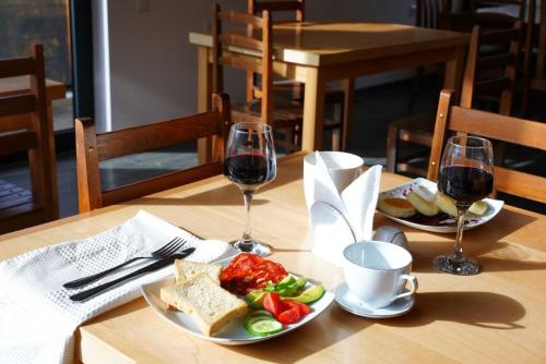 Lastili Inn Hotel في ميستيا: طاولة مع طبقين من الطعام وكأسين من النبيذ