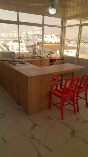a kitchen with red chairs and a counter with a stove at Semi Amoblado Manta Mall del Pacifico; Playa Murciélago in Manta