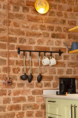 a kitchen with utensils hanging on a brick wall at Lemon Apartments in Istanbul