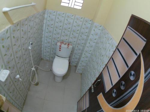 a small bathroom with a toilet in a room at Hotel Rongdhanu Residential in Dhaka