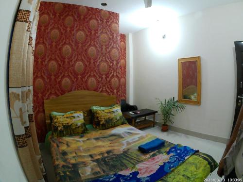 ein Schlafzimmer mit einem Bett und einer roten Wand in der Unterkunft Hotel Rongdhanu Residential in Dhaka