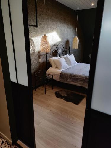 a bedroom with a bed with two lamps on it at La folie 20 Spa in Hon-Hergies