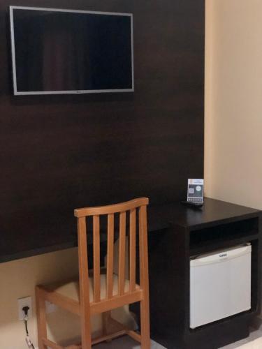 a wooden chair sitting in front of a black desk at Hotel Villa de Minas in Monte Sião