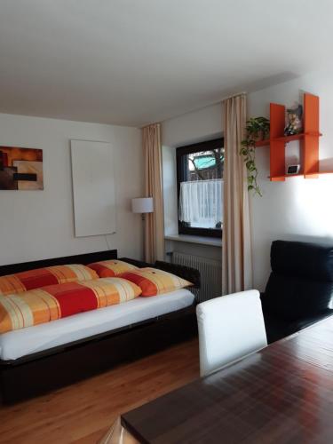 1 dormitorio con 1 cama, 1 silla y 1 ventana en App. Brunner en Valdaora