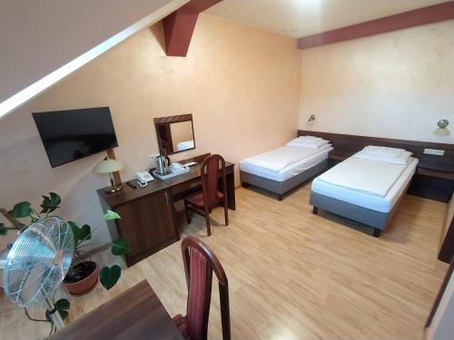 um quarto de hotel com duas camas e uma secretária em Restauracja Kargul noclegi em Leczyca