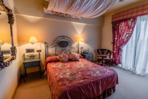 a bedroom with a large bed with a red bedspread at Hotel Alhama in Cintruénigo