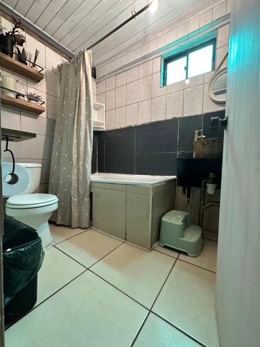 Un baño con bañera, inodoro y lavabo. en Cabañas Hostal Punta de Lobos Surf & Relax, en Pichilemu