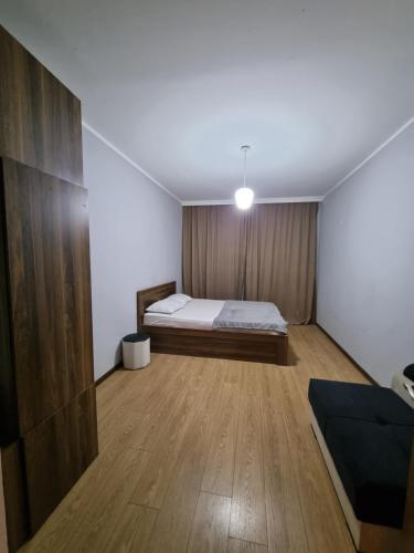 a bedroom with a bed and a wooden floor at Green Garden - Crimea in Tbilisi City