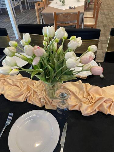 a vase of white and pink tulips on a table at Hotel Aroma in Përmet