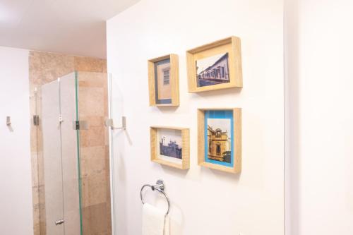 ein Badezimmer mit vier Bildern an der Wand in der Unterkunft Habitación Privada para disfrutar en la Ciudad de México in Mexiko-Stadt
