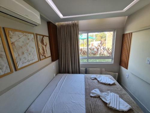 a bedroom with a large bed with a window at Fuja para o Paraíso em Porto de Galinhas! in Porto De Galinhas