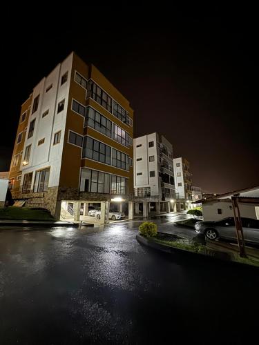 a parking lot with two tall buildings at night at Apartamento con vista espectacular a 5 minutos del parque del café in Quindío