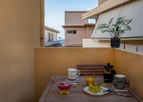 una mesa con una bandeja de fruta en el balcón en Upper Samitos Rooms en Áyios Andónios