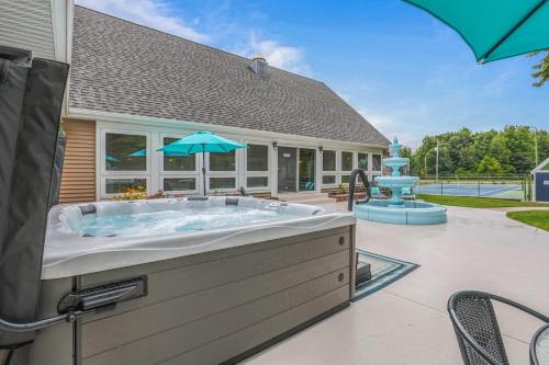 a hot tub in a backyard with an umbrella at Indoor Pool Near Grand Haven & Lake Michigan Beach in Spring Lake