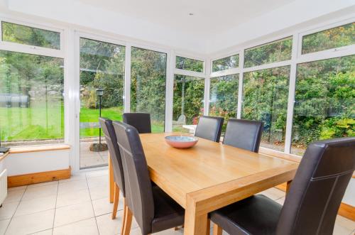 a dining room with a wooden table and chairs at Rathmullan Village Home in Rathmullan