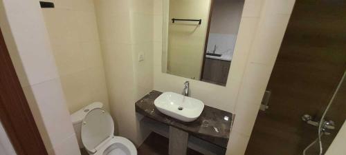 a bathroom with a toilet and a sink and a mirror at SleepRest @ NTC in Nagoya