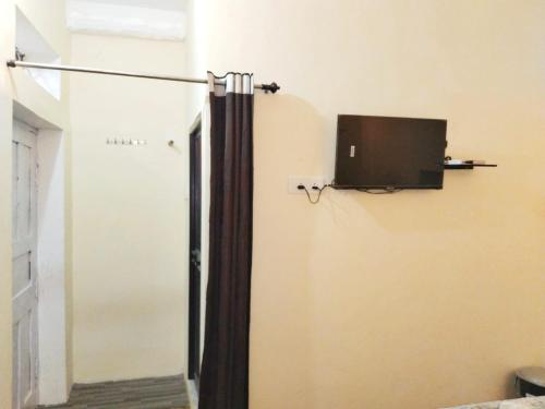 Zimmer mit Tür und TV an der Wand in der Unterkunft BAGH VILLA HOME STAY in Rājgarh
