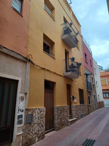 ein gelbes Gebäude mit Balkonen auf einer Straße in der Unterkunft DUNA Y DANA in Palamós