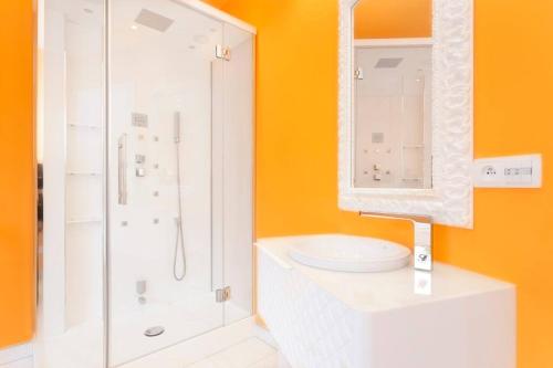 ein weißes Bad mit einer Dusche und einem Waschbecken in der Unterkunft L'Atelier 4 stars Luxury, Hot Tub, Pool in Nambsheim