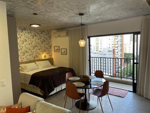 a bedroom with a bed and a table and chairs at Vida Urbana - Allure - Setor Oeste in Goiânia