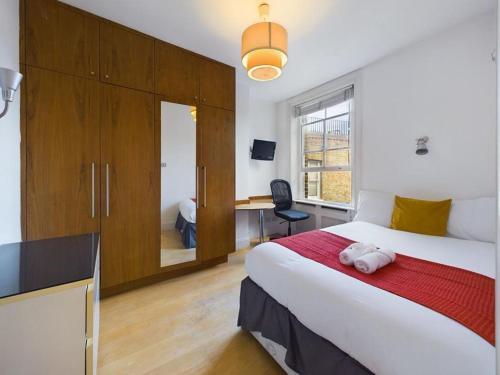 een slaapkamer met een bed en een bureau in een kamer bij Luxury 4 Bedroom 2 Bathroom House Westminister Big Ben in Londen