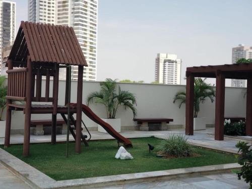 a playground with a slide and a bench and buildings at Banho de Lua - Vaca Brava in Goiânia