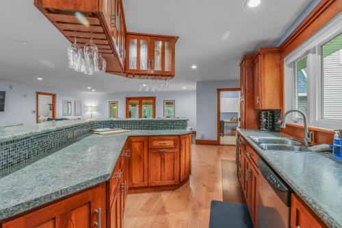a kitchen with wooden cabinets and granite counter tops at Indoor Pool Near Grand Haven & Lake Michigan Beach in Spring Lake
