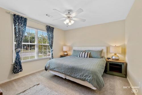 a bedroom with a bed with a ceiling fan and a window at The Alberta Cottage in Fayetteville