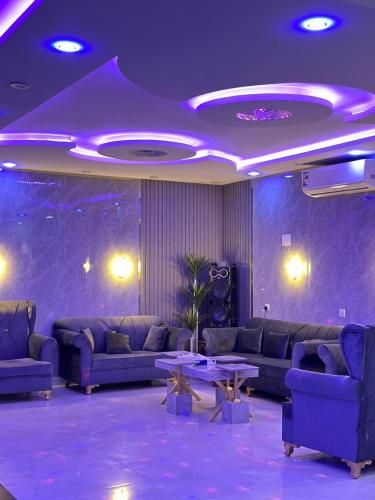 a purple room with couches and a table at شاليه الفخامه٢ in Ḑubā