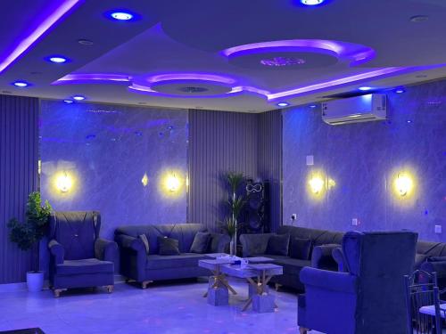 a living room with couches and tables and purple lighting at شاليه الفخامه٢ in Ḑubā