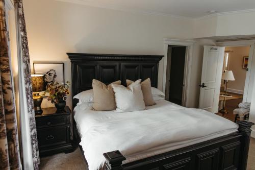 a bedroom with a large bed with white sheets and pillows at Southmoreland at Oak Street Mansion in Kansas City