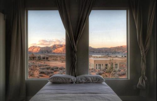 a bedroom with a large window with a view of the desert at Page Arizona border town- Grand Serenity room with Mesa Views in Big Water