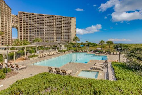 a swimming pool with lounge chairs and a resort at Walk to Beach and Barefoot Landing Resort Condo! in Myrtle Beach