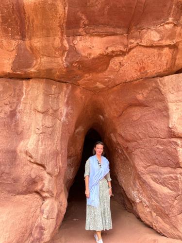 a woman standing in front of a cave in a rock at Space camp in Wadi Rum