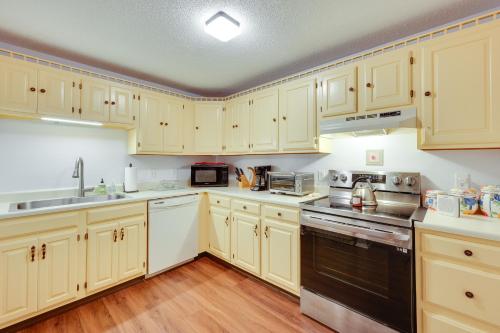a kitchen with white cabinets and a black appliance at Inviting Bartlett Condo 1 Mi to Attitash Mountain in Bartlett