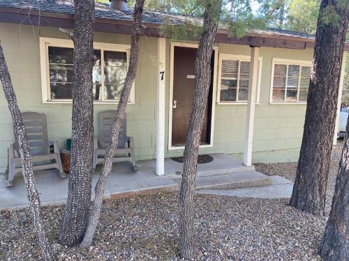 uma casa com duas cadeiras e um alpendre com árvores em Hidden Rest Cabins and Resort em Lake of the Woods