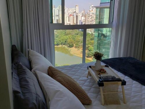a bedroom with a bed with a large window at Nature - Easy Life - Vaca Brava in Goiânia