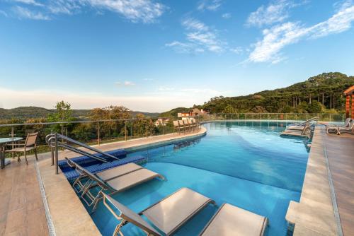 una piscina con tumbonas en el balcón en Laghetto Resort Golden Oficial en Gramado