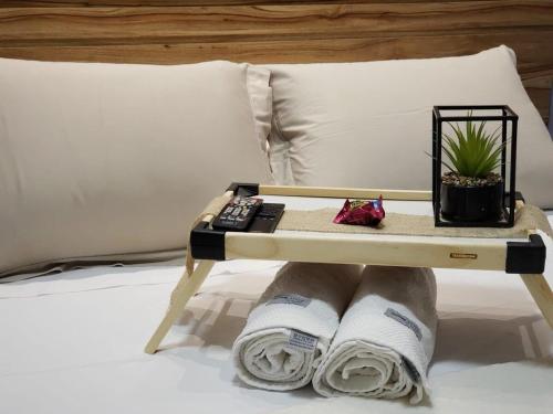 a tray with a remote control and a plant on a bed at Pulse - Easy Life - Vaca Brava in Goiânia