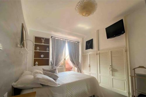 um quarto branco com uma cama e uma televisão em L’Attico Sul Fiume center home em Ascoli Piceno