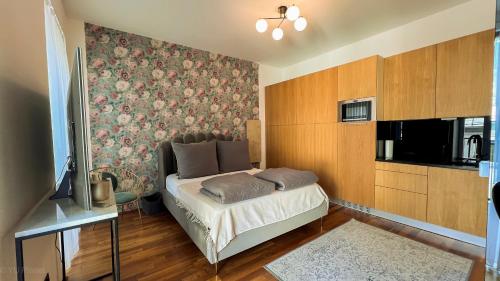 een slaapkamer met een bed met bloemenbehang bij Triangle City Center Apartment in Wenen