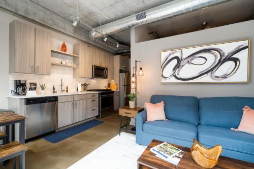 sala de estar con sofá azul y cocina en Minnestay Sable 35 - One Bedroom en Minneapolis