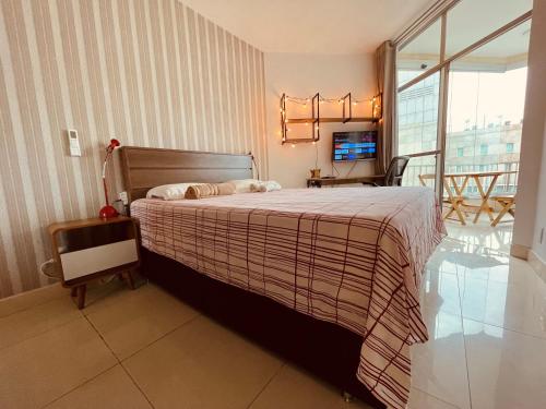 a bedroom with a bed and a television in it at Pé na areia! Apart hotel com vista para o mar e lazer completo! Front beach apartment with ocean view and amenities! in Rio de Janeiro